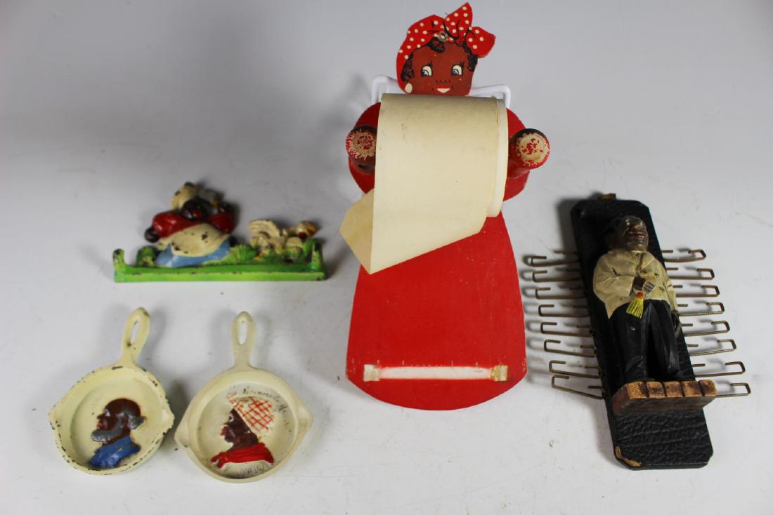 Black Americana Group: Including the cast iron butcher chasing the chicken ket or pot holder, two cast iron small ashtrays pans, wood paper dispenser that looks like toilet paper and the butler hook. All in fair condition a
