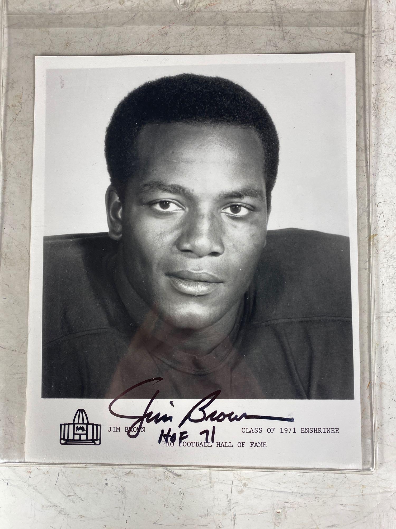 (2) Jim Brown Autographed HOF Enshrinee Photos: Two black and white photos signed in black sharpie along with "HOF 71" inscription. One is MINT and one has an ever so small smudge. Great addition to your collection! Comes with an Auction House LOA