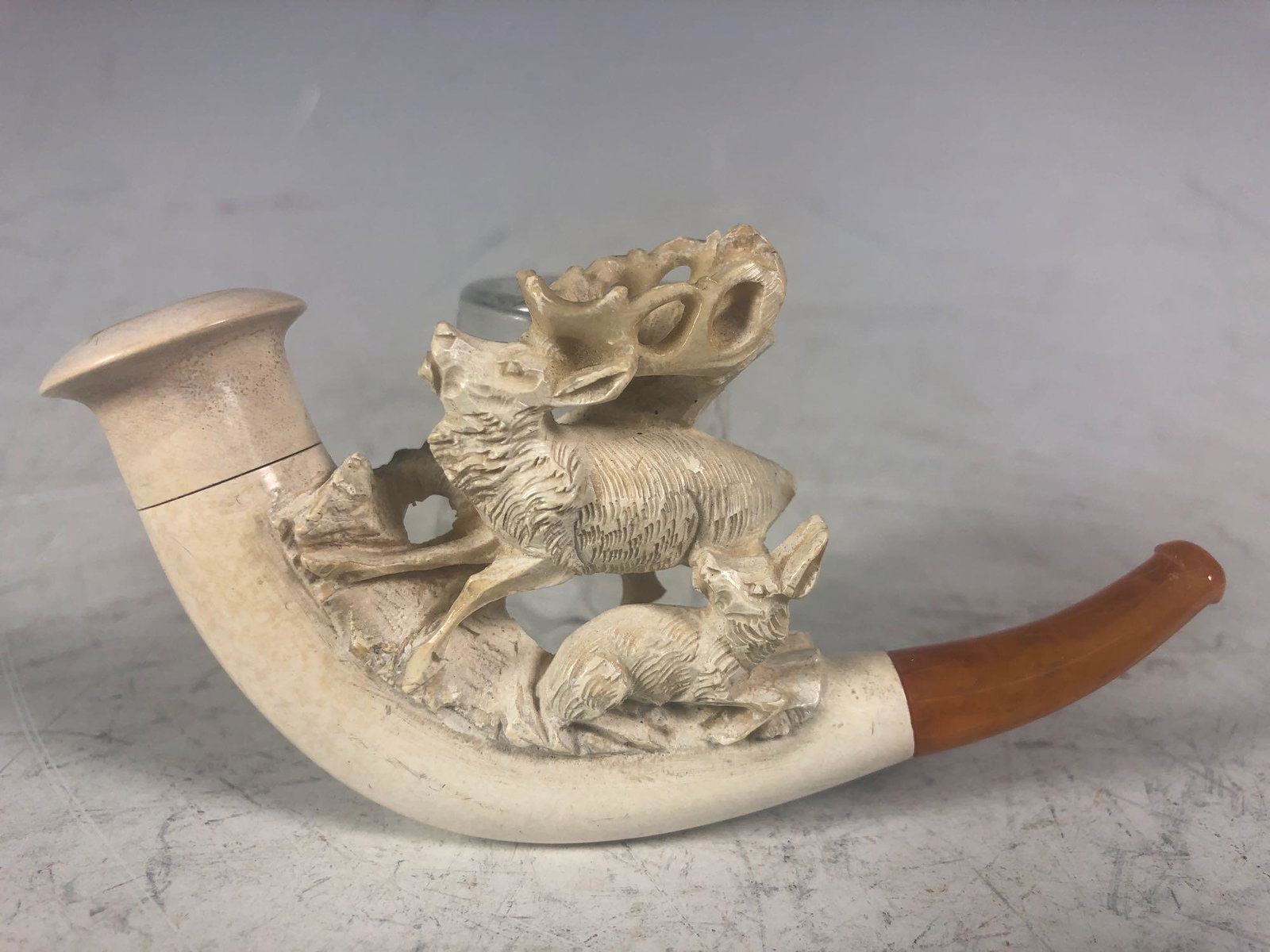 Carved Meerschaum Tobacco Pipe: Fine signed, carved meerschaum pipe having large carved stag or deer (male) with young doe or fawn laying next to the stage.Â Hand carved with Bakelite mouth piece tip and having original lather wr