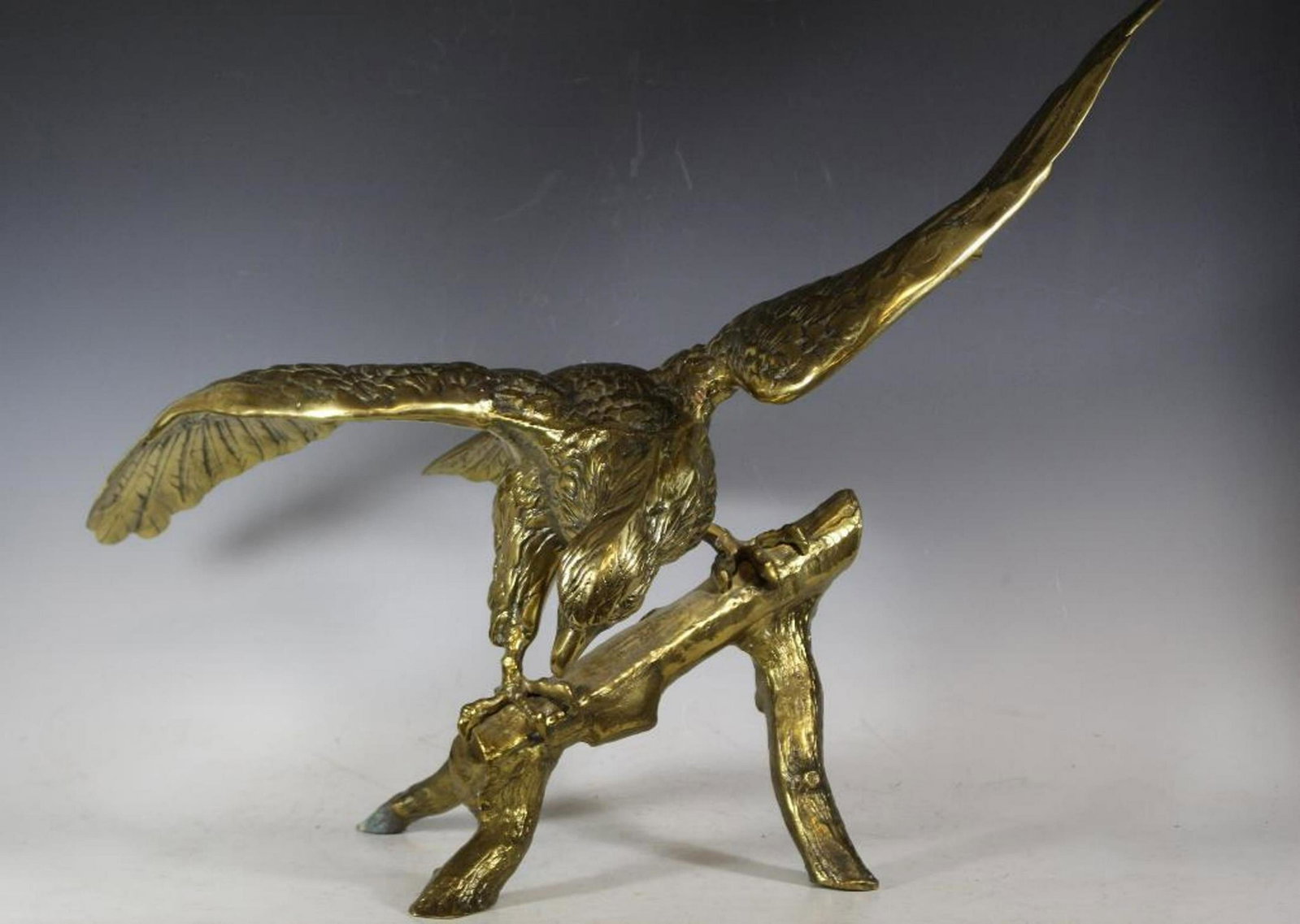 Ornate 20th Century American Eagle Statue: Fine quality, iconic of American is this large brass detailed statue of the American Bald Eagle set to take flight from perched branch. Measuring approx 36" wingspan x 24" tall. Late 20th century deco
