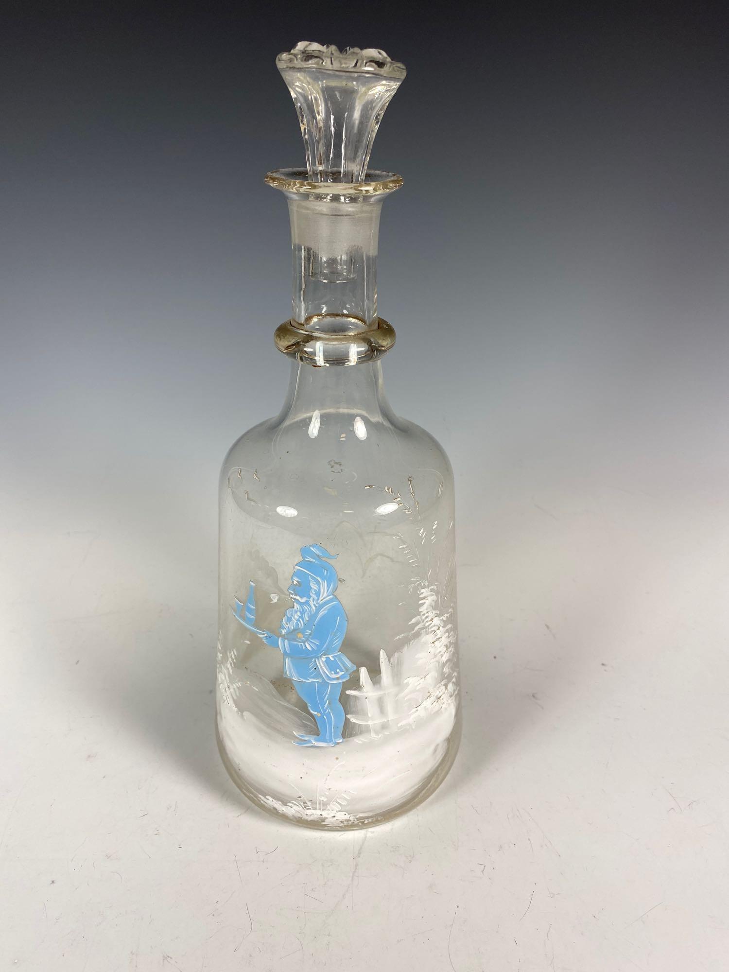 Mary Gregory Hand Painted Glass Decanter with GNOME: Unusual hand painted Mary Gregory liquor decanter with winter scene featuring a Gnome like character smoking a pipe. Measuring approx 11in tall with stopper. Some light signs of use as shown, see phot