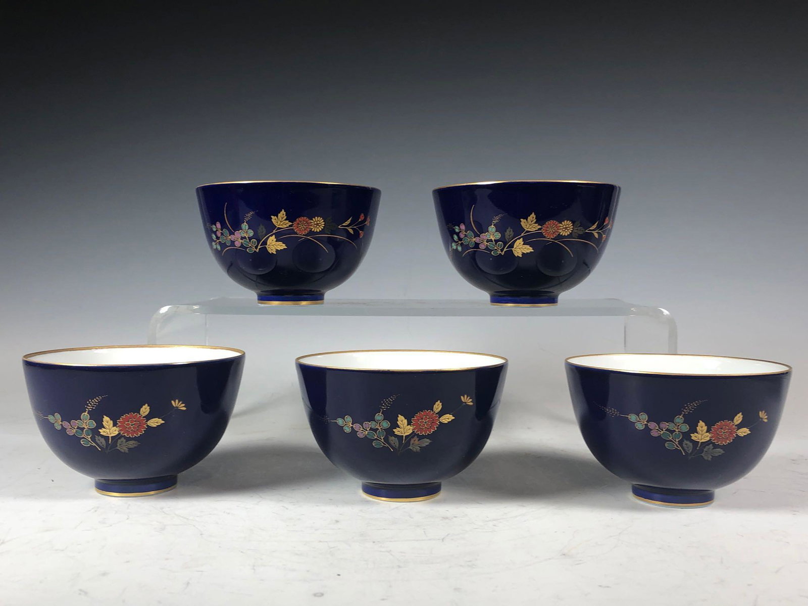 Five 20th Century Chinese Porcelain Tea Cups: Set of five Chinese handle less tea cups with cobalt blue glaze, floral decorated and gold rim. Stamp marks on bases as shown, see photos. Measuring approx 3.5in diameter and 2.25in tall. Good conditi