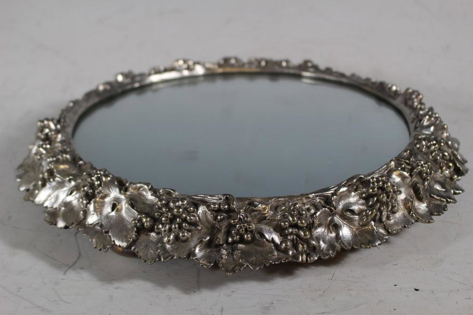 Elkington Silver Plate Plateau Mirror: Elkington & Co. Silver plate plateau mirror. Berries and Leaves Pattern with a solid natural wood base insert. Signed under the foot edge as shown. very good condition as shown. Measuring approx 14" d