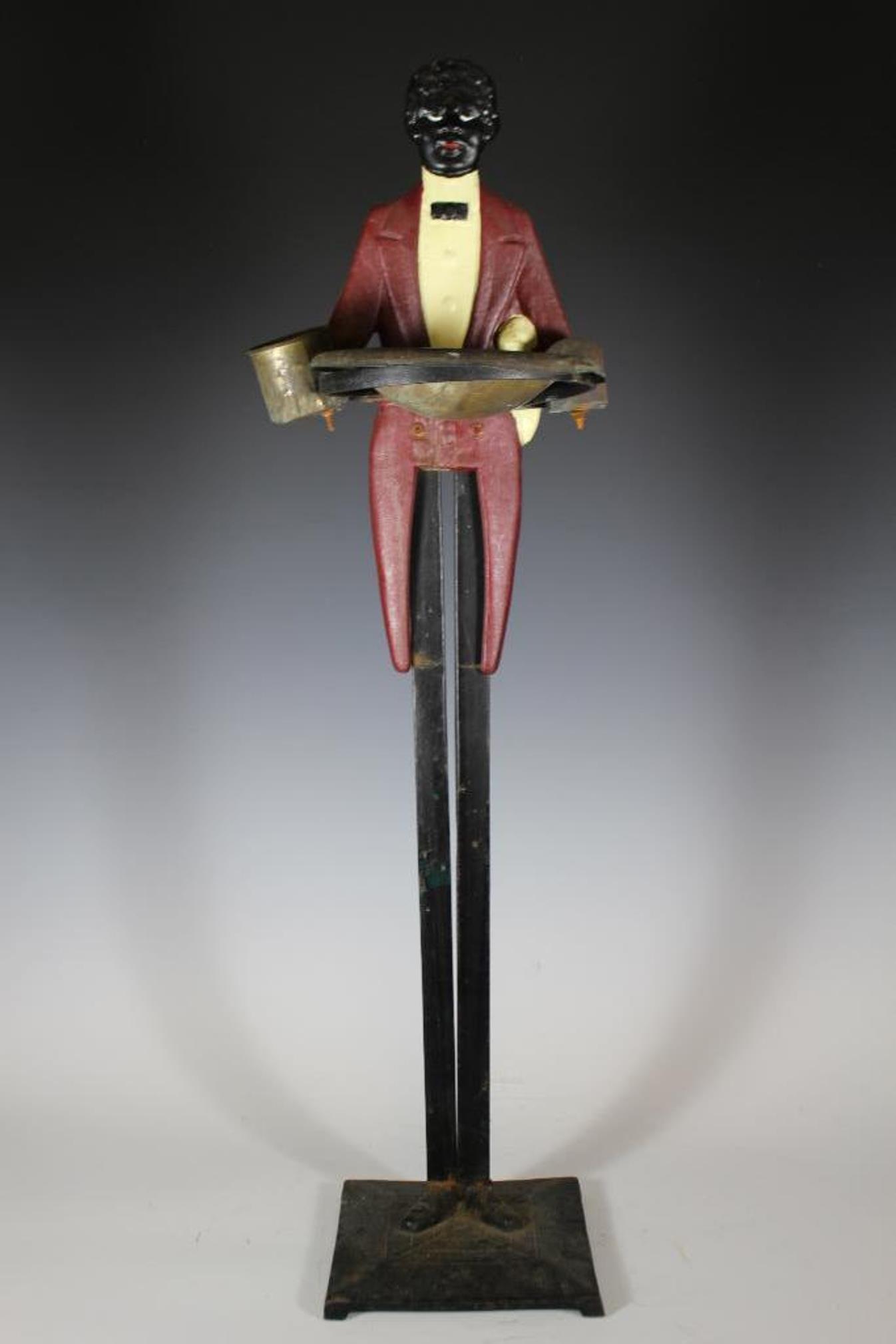 20th Century Blackamoor Butler Smoke Stand: Late 20th century black Americana figural floor standing smoke stand or ash tray. Depicts a black gentleman dressed as a butler with copper ashtray, match stand and cigarette holder on cast iron base.