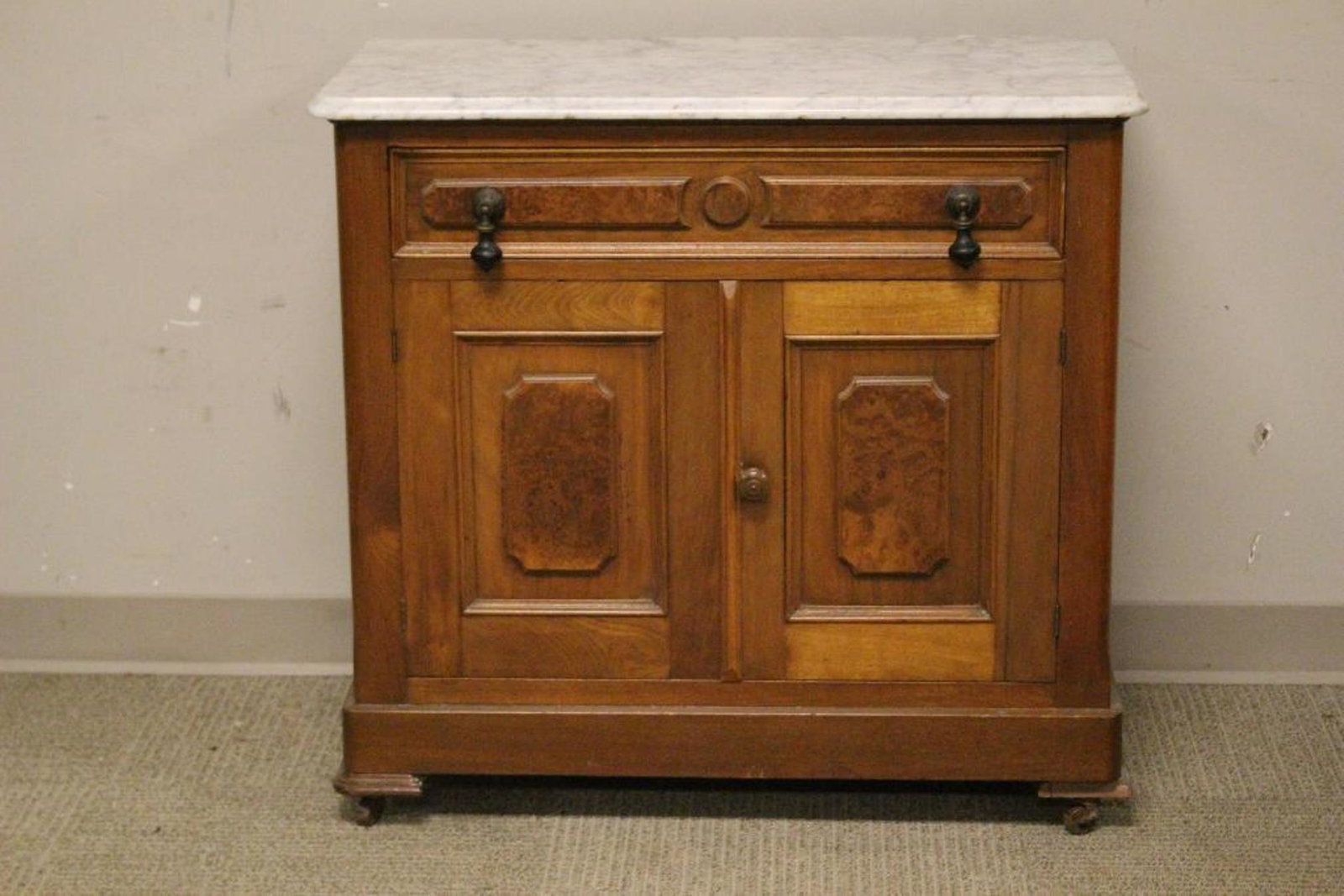 Mid Victorian American Marble Top Washstand: 1880-90 American walnut washstand with marble top and burled raised panel doors having ebonized tear drop style pulls. Measuring approx 31" tall x 33" wide x 17" deep. Note fitted for backsplash, alth