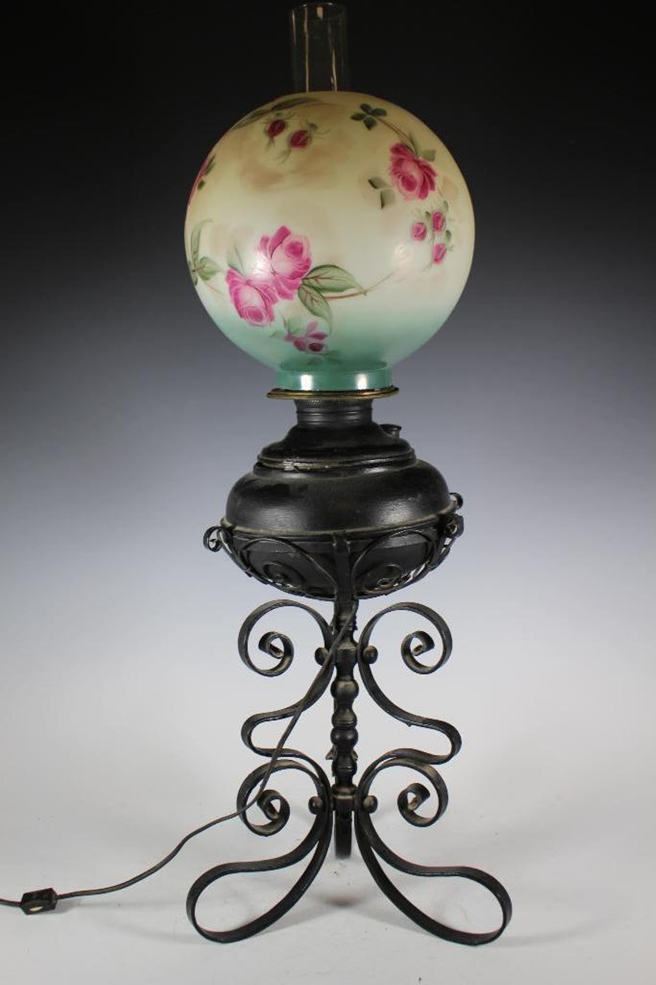 Aladdin Electrified Glass Lamp: Electrified late 19th century Aladdin oil lamp with signed hand painted floral shade. Iron base with black paint, working condition as shown. Measuring approx 33" tall. Marked on side of font and oil