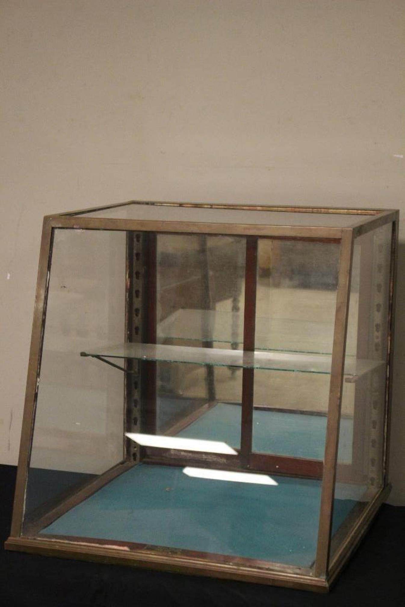 Early Countertop Bronze Showcase: Late 19th early 20th century glass table top display case edged in bronze with mirrored sliding doors with one shelf. Having original plaque reading "Isaac Mclean Sons Co" Boston Mass.. Approx. 24" ta