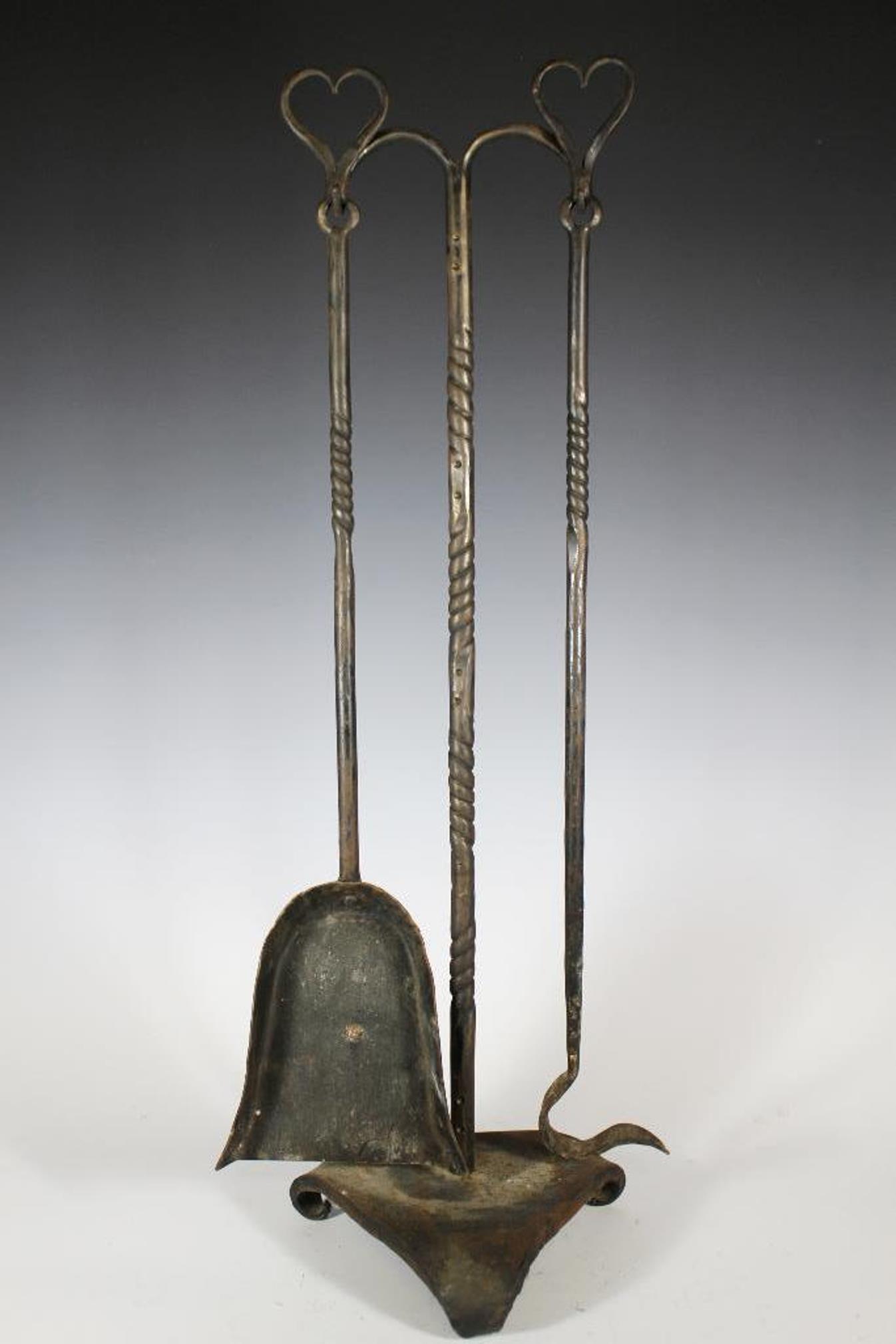 Fine Arts and Crafts Era Fireplace Set: Arts and Crafts era cast iron fireplace tools set with stand in twisted brass and iron top adorned with hearts. Approx. 29' tall in good age appropriate condition, see photos.