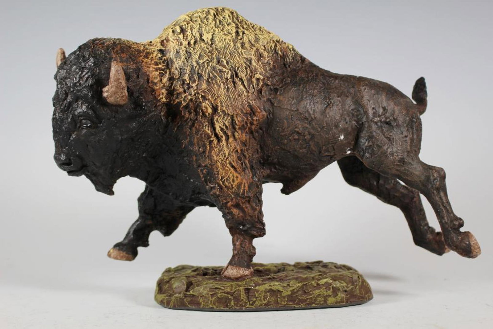 Dale Monfort Original Buffalo: Signed D. Monfort 1996 with original paper tag running buffalo sculpture. Approx. 14" long by 9" tall in good condition with a few tiny paint chips.