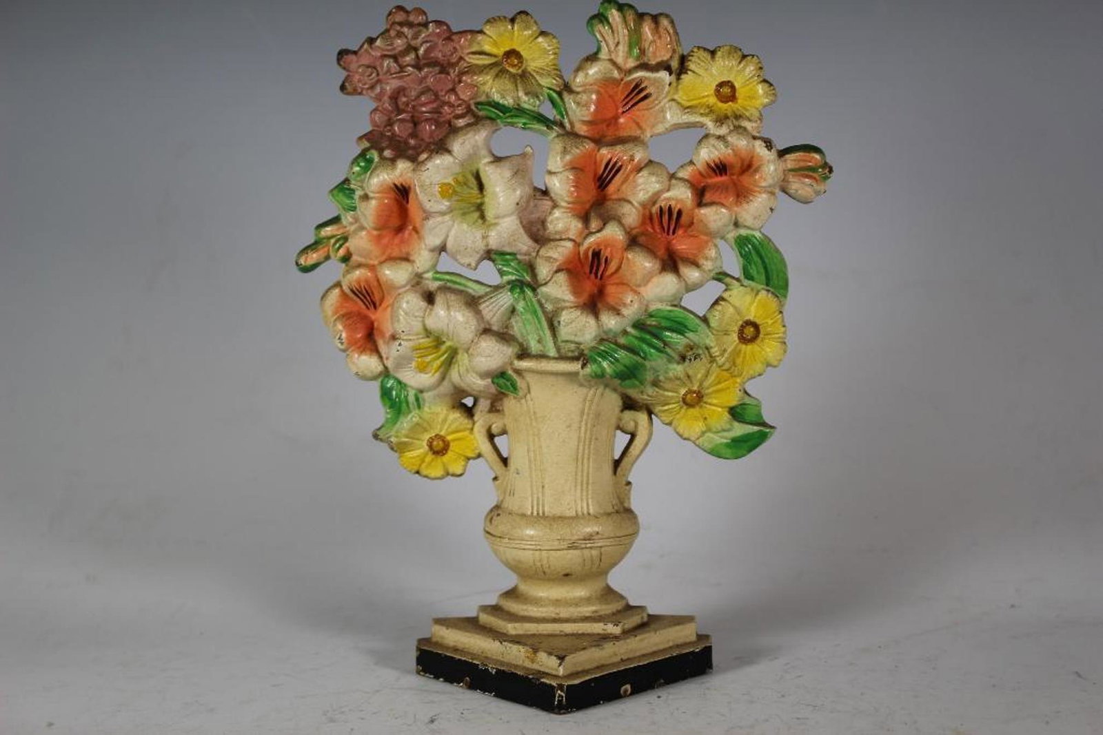 Painted Cast Iron Floral Doorstop: American 1920's cast iron floral door stop with original paint. Unmarked, most likely Hubley. Measuring approx 10" tall x 8" wide, see photos.