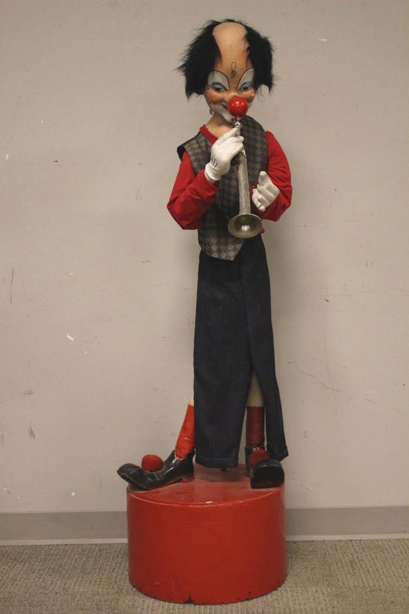 1930's Electric Automatons Clown: Antique 56" automatons electric clown playing trumpet with light up nose. In working condition, clown moves left and right standing on wood base. There is some loss to plaster mainly to back bottom ed