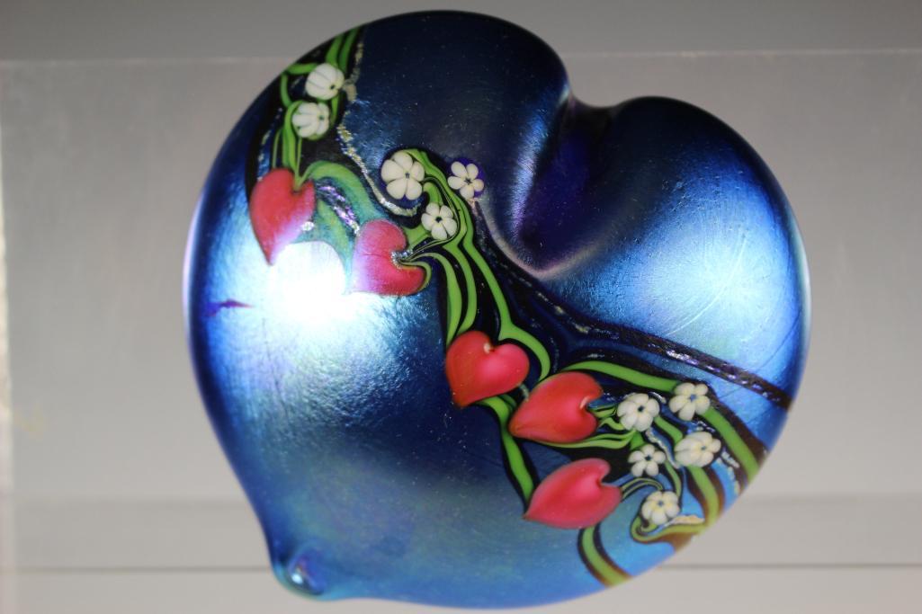 Orient and Flume Signed Paperweight: Signed and numbered 24/250 with original sticker and signed C. Hasler. iridescent blue and floral decor. Approx. 2" tall by 4 1/2" wide. In good condition with a scuff to left side, see photos.