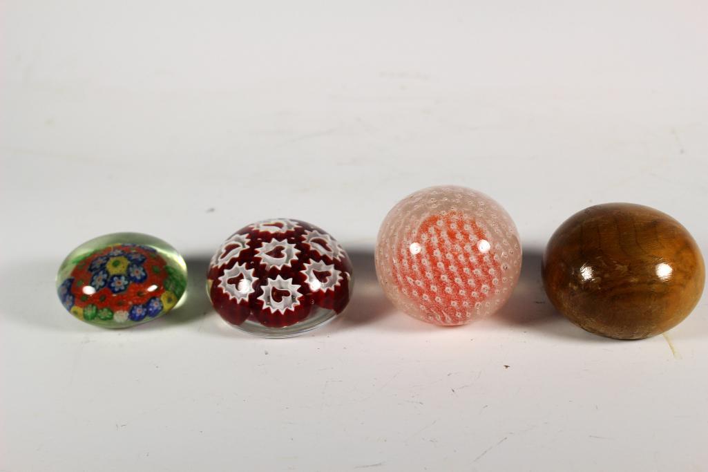 Collection of Four Glass and Wood Paperweights: Includes three blown art glass paperweights unsigned and one wood by Kenneth Molitor. Approx. 1 1/4" to 2 1/4' tall. In good condition with some small scratches, see photos.