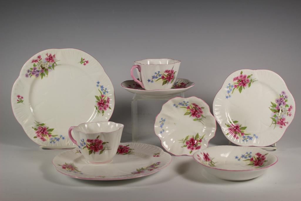 Eight Piece Shelley Bone China Stocks Pattern: Shelley Bone China "Stocks" pattern group. Includes; 2 pink handled tea cups, 1 saucer, 1 snack tray saucers, 6" plate, 8" plate, fruit bowl and condiment dish. In good age appropriate condition.