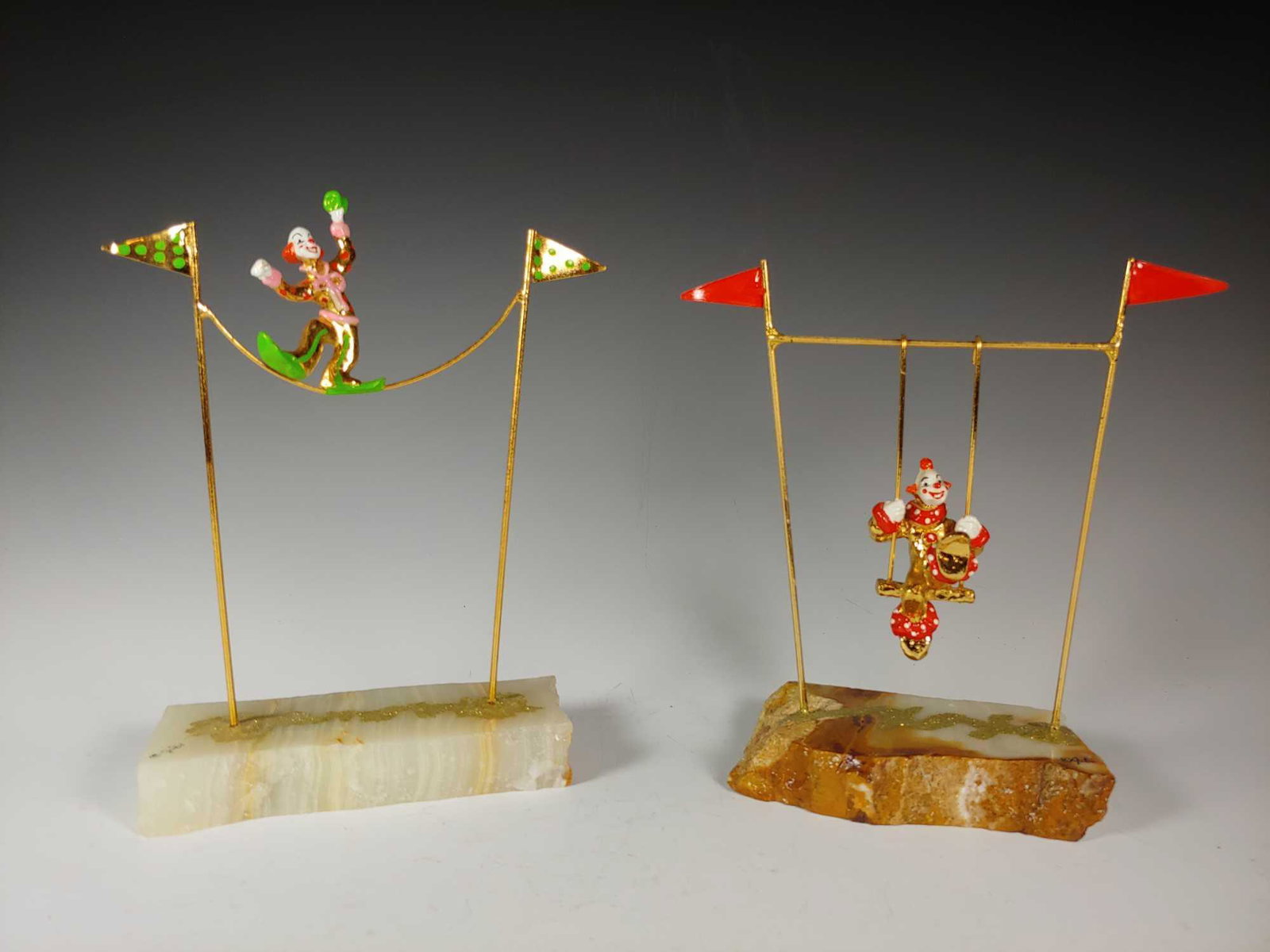 Judi Originals 24K Gold Plated Circus Clowns: Includes high wire walking clown and swinging clown which is two pieces. Both signed on bases. Approx. 7 1/2" to 8 1/2" tall. Both in good condition, see photos.