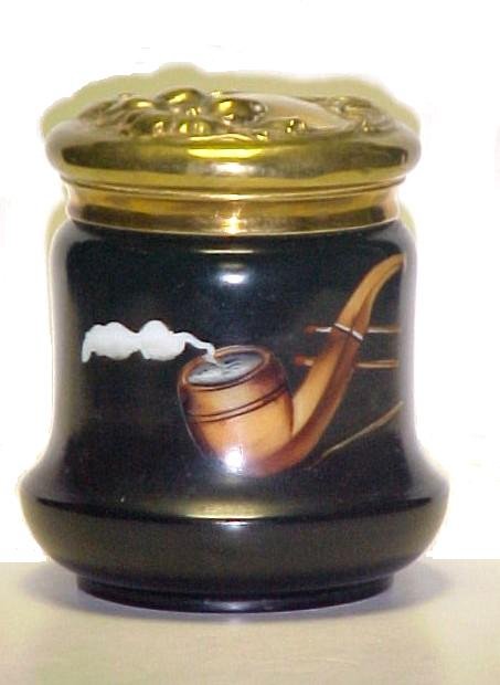 Attributed To Wave Crest Humidor: decorated with smoking pipe and matches, lid has raised floral design. Condition minor nicks to glass rim, small dent in lid paint good. h.6 1/2''