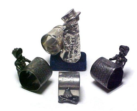 Four Victorian Silver Plated Figural Napkin Rings: compromising of matched pair of young girls in bonnets, young lad in top coat and hat and on mounted on branches. Condition all with worn finish and some bending to rings.