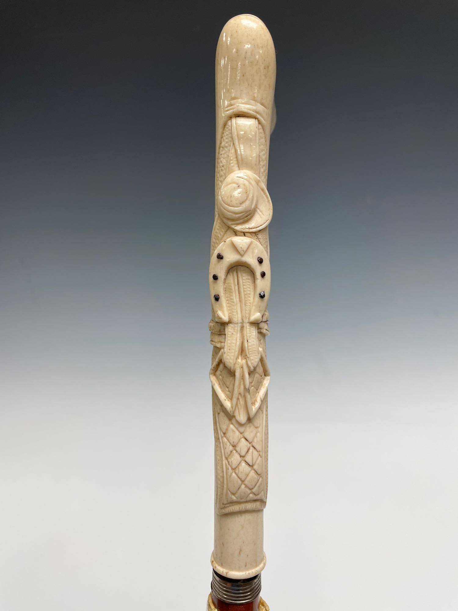 Early 20th Century Cowboy Western Motif Hand Carved: Hand bone carved cane topper with western cowboy features such as horseshoe, saddle straps and cowboy hat. 35" tall see photos