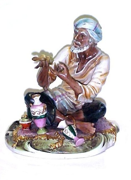 Capi Demonti Figure Arabian Street Vendor, : sitting on pillow showing his ware's. Crown Mark and number 602. Chip on underside and possibly some old touch up ? Figure needs cleaning.