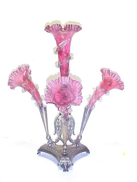 Victorian Epergne Assembled From Parts,: having and ornate silver over brass holder, with 4 cranberry flutes. Flutes do not fit tight in frame note pictures, can very easily be modified with some ingenuity. Bid accordingly. Flutes are all go
