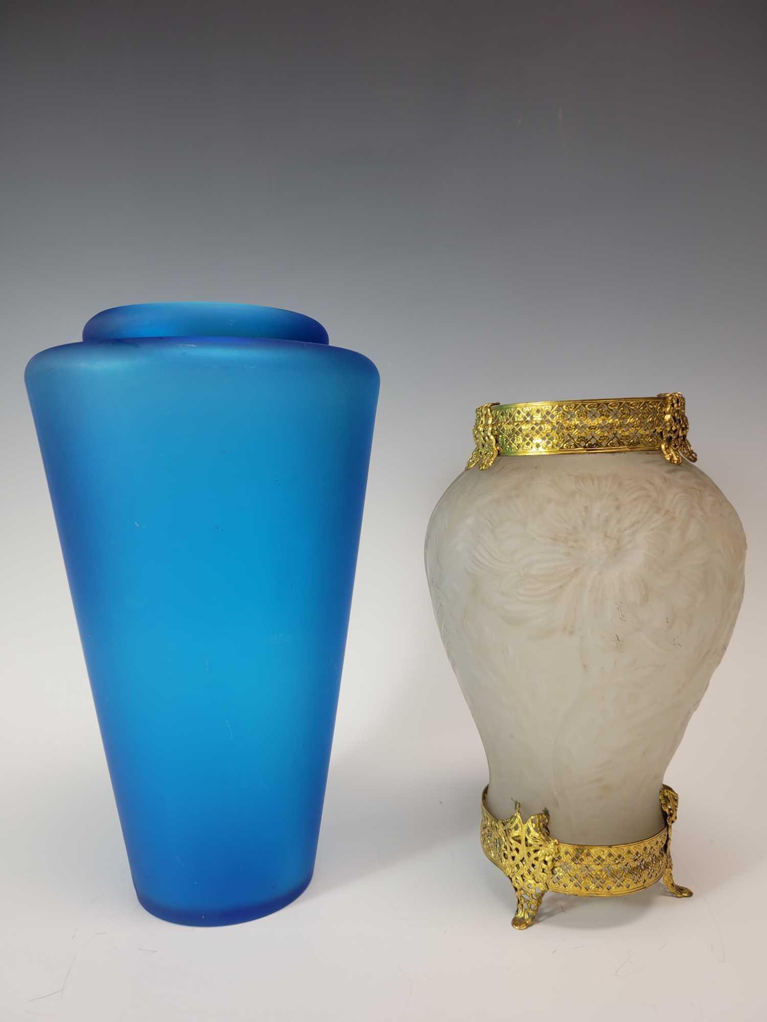 Frosted Glass Embossed Sunflower Vase and Blue Cylinder: Frosted glass embossed sunflower vase sitting on three legged gold base and gold trimmed rim along with opaque blue glass cylinder vase. Sunflower vase measuring approx. 9" tall and blue vase 10.5" ta