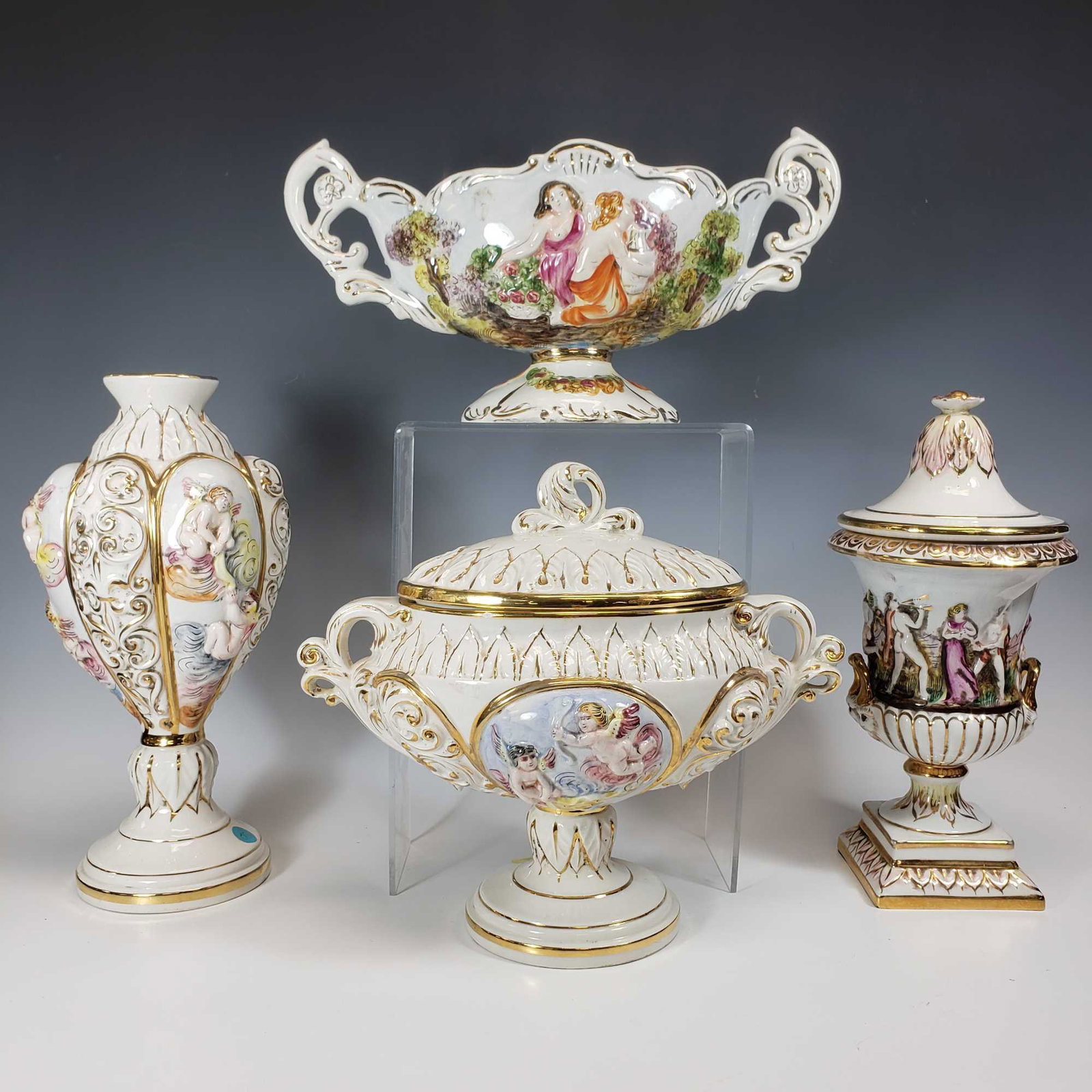 Keramos Capodimonte Italy Porcelain (4): Includes; bulbous vase with cherubs and gold trim, lidded pedestal urn with nude men and women dancing with faces under handles, handled centerpiece bowl with women and half naked woman and pedestal l