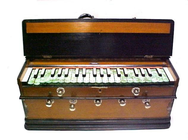 Unusual Musical-Instrument Piano- Melodeon Type, N: table top or possible had neck strap for strolling and playing. Never saw this model before. Having sliding lift top, pull out knob's and bellows in back that open out. Condition in working order may