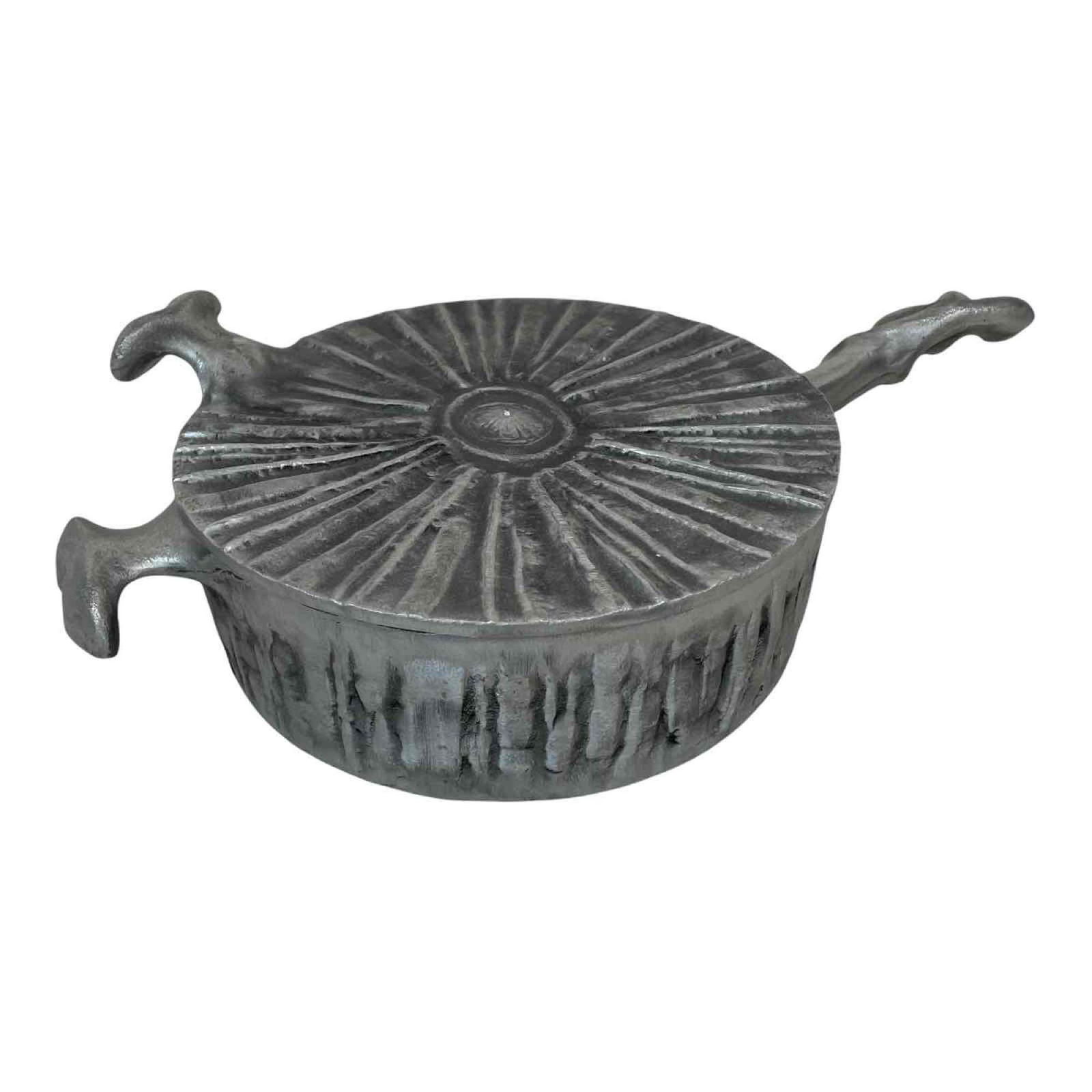 Early Don Drumm Skillet: A Brutalist round covered skillet from Don Drumm's early work with matte finish, c. 1970s. Signed on base "Drumm / 3 Qt". Approximate dimensions: 4 1/4" h. x 17" l. (handle-to-handle) x 10" diameter.