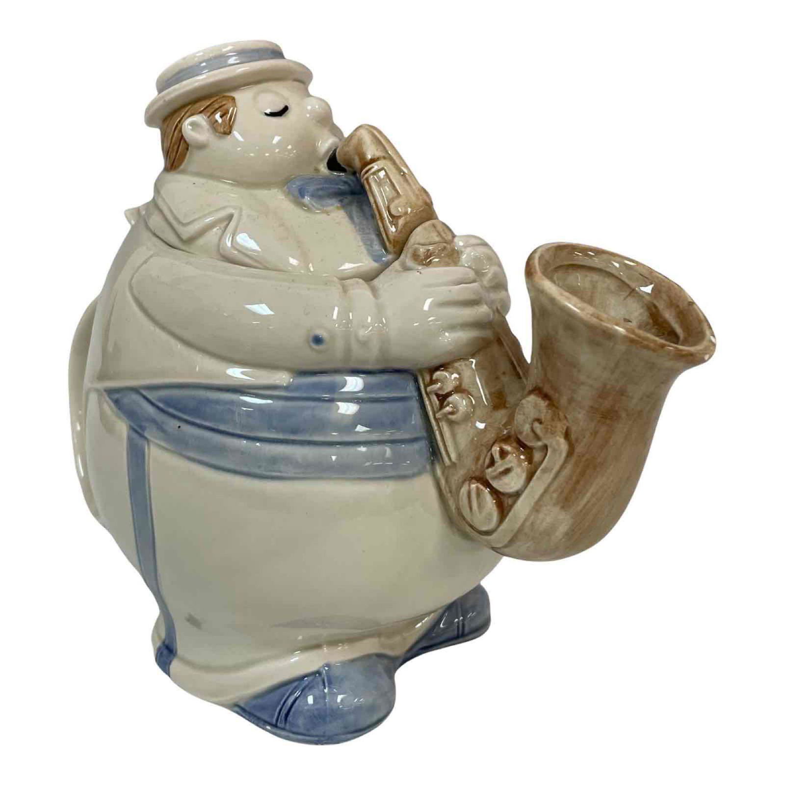 Fitz &Floyd Saxophone Player Teapot: A 1979 vintage figural teapot of man playing the saxophone by Fitz and Floyd as shown with black ink stamp on bottom. Overall good condition as shown, see photos. Measuring approx 7" tall x 10" wide.