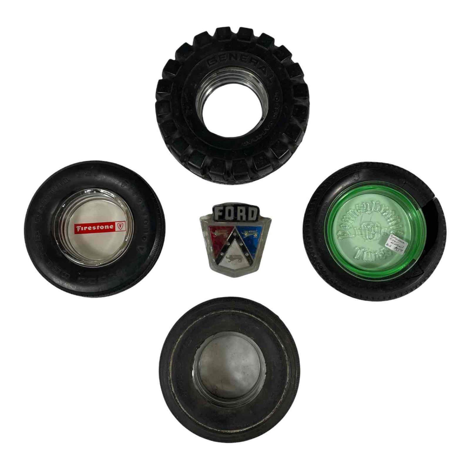Advertising Tire Ashtrays and Ford Emblem: Four vintage tire advertising ashtrays and Ford emblem. Ashtrays are in the form of tires from, Firestone, Pennsylvania and General with glass trays and vintage Ford emblem. Showing signs of age and w