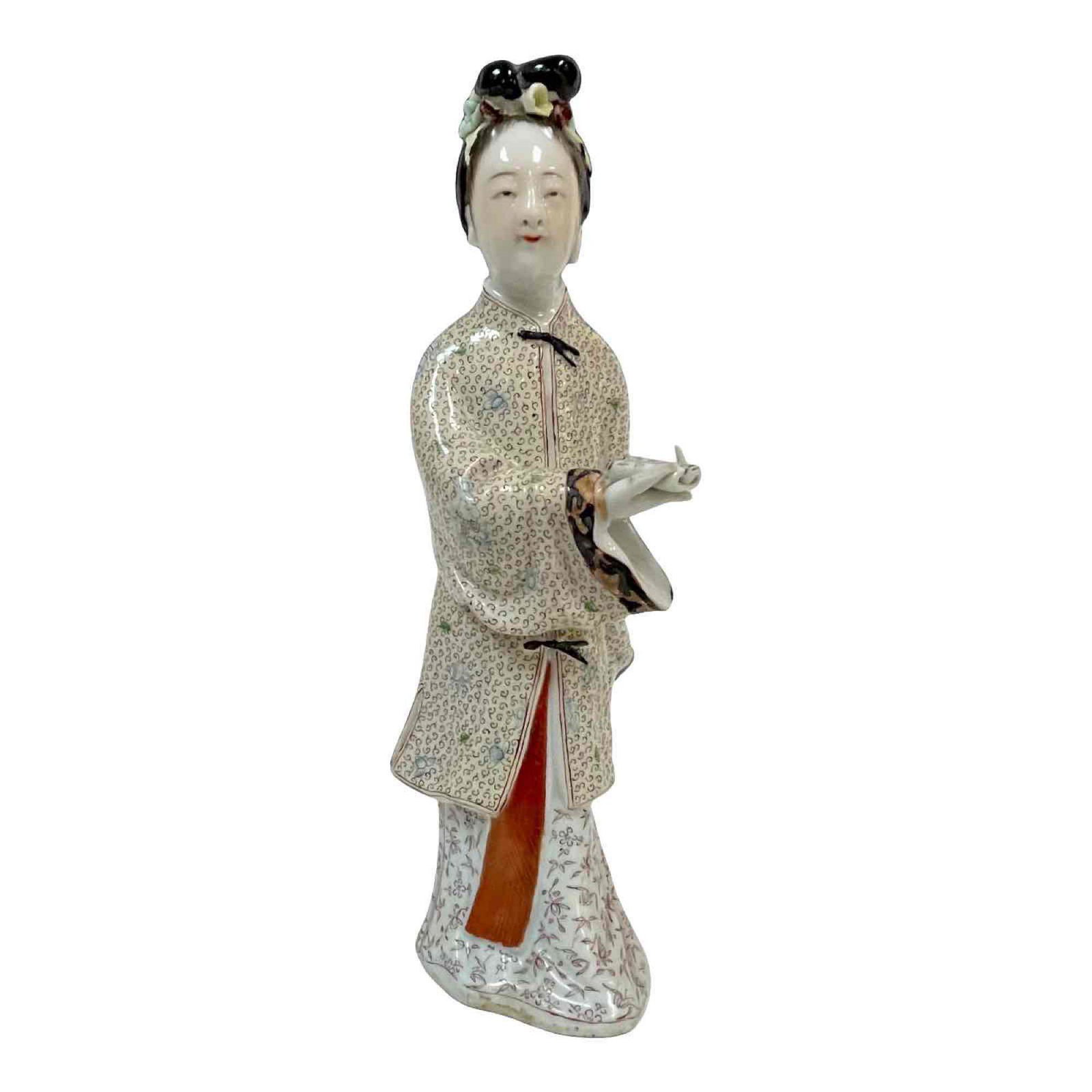 Chinese Hand-painted Porcelain Figurine: A finely painted Chinese porcelain figurine wearing a coat and dress with complex designs. Note condition, missing fingers and parts of the flowers in her hair. Approx height 8".