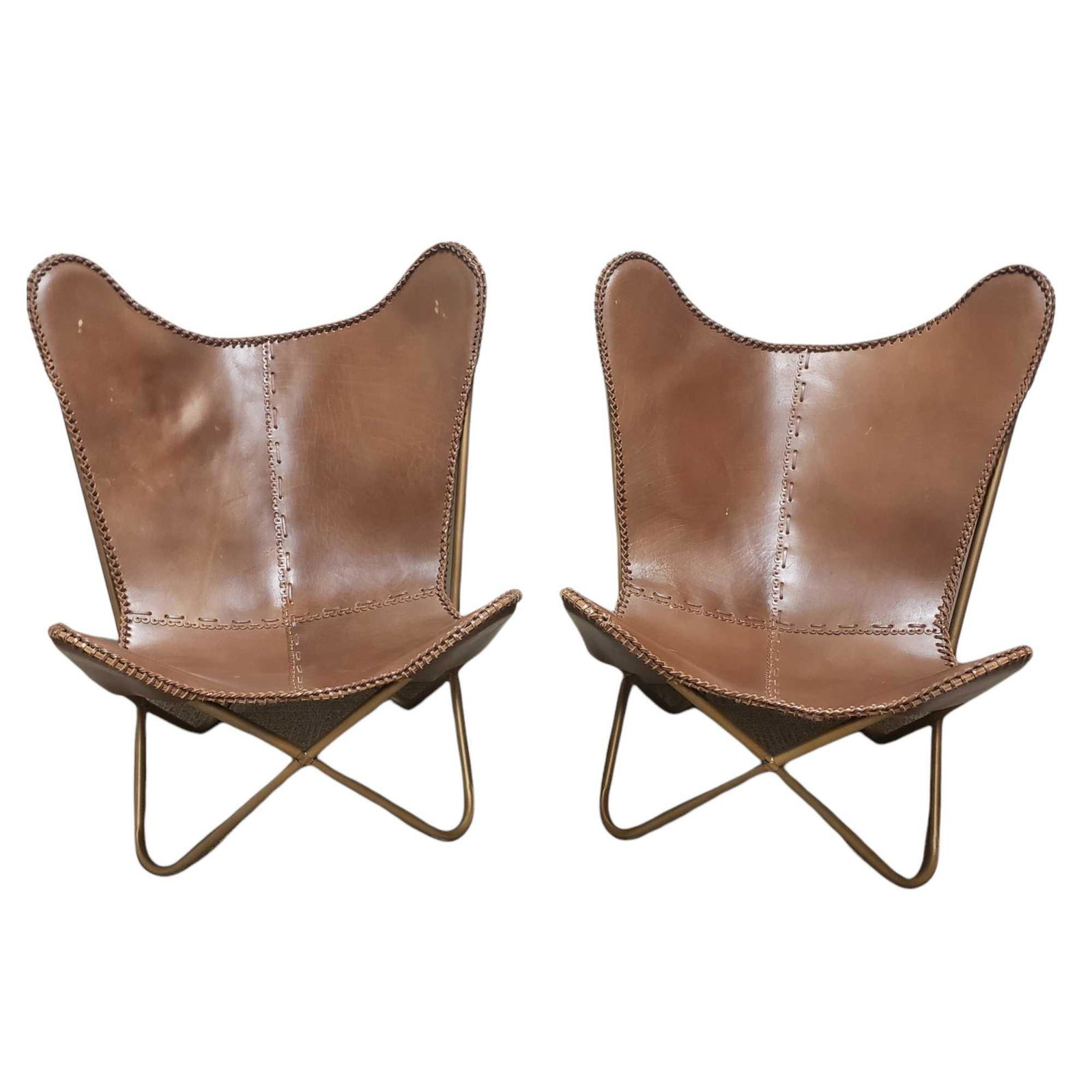 Pair of Iconic Brown Stitched Leather Butterfly Chairs: Pair of sling style butterfly chairs with brown stitched hide leather on tan metal frames. After the original iconic designed chairs by Jorge Ferrari-Hardoy. No found maker marks, appear to be later 2