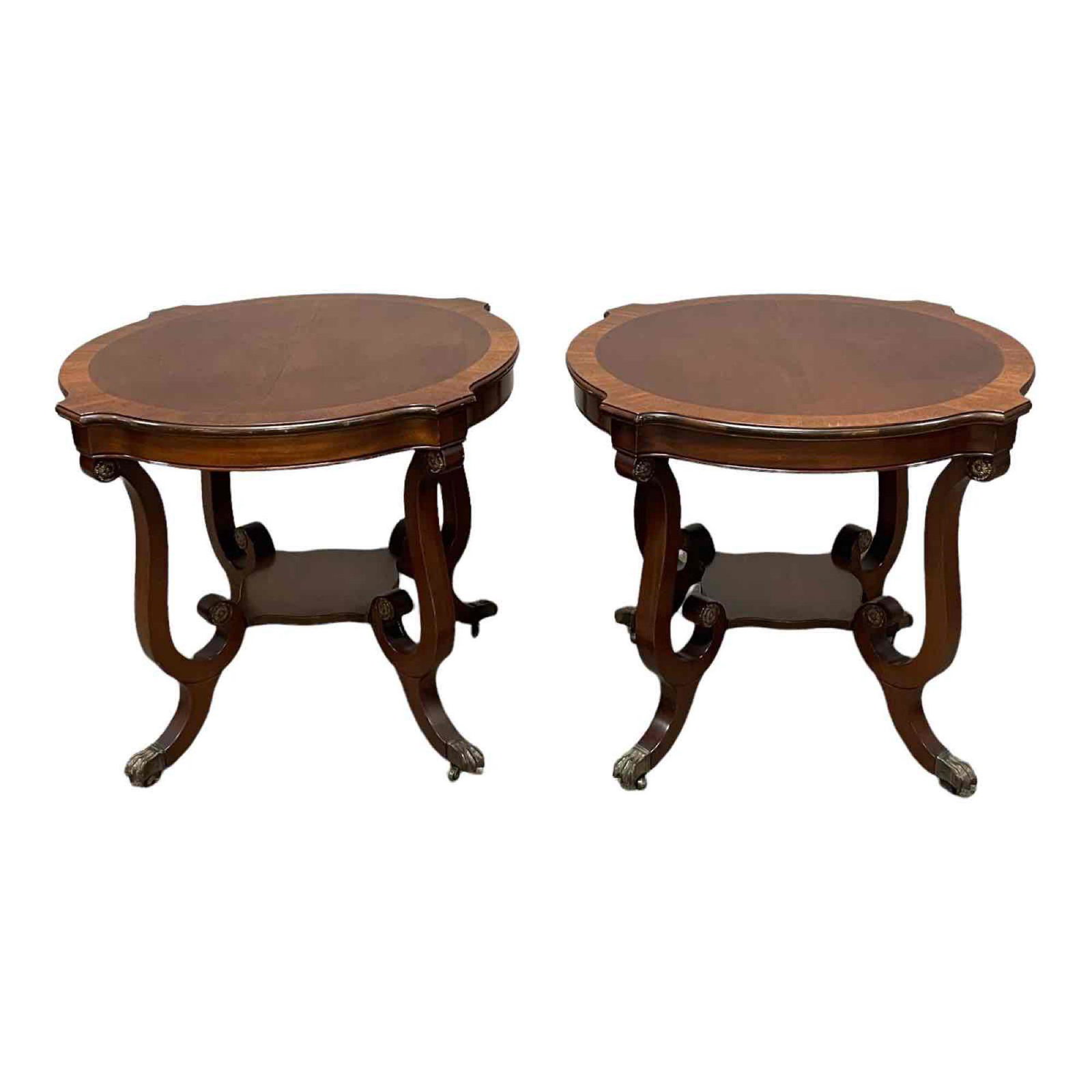 Quality Pair of 20th c. American Mahogany Tables: Pair of 1940's, American Empire Duncan Phyfe style mahogany parlor tables with banded top, lower rier shelf and hairy paw brass capped feet. Measuring approx 27" tall by 37" diameter. Normal scuffs an