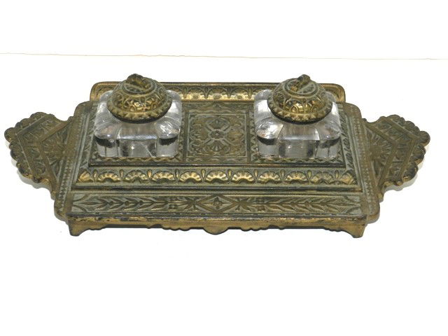 Victorian Double Ink Well: With embossing aesthetic movement detail throughout the 11" cast frame and caps on glass ink botles. Center bottle are with a raised area which allows for the double sided pen holder. Some sort of exe