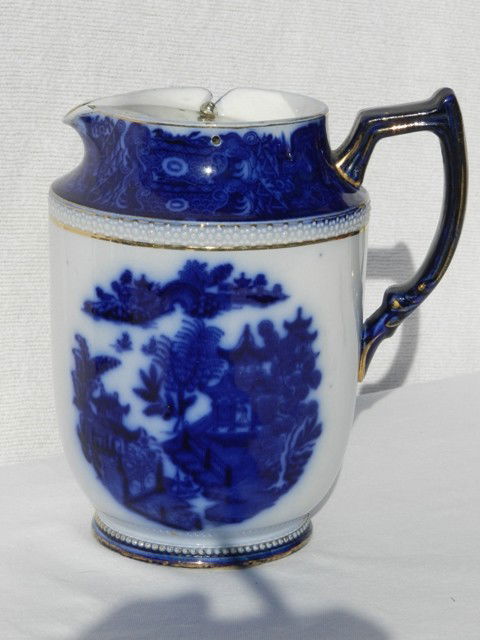 Carlton Ware Flow Blue Pitcher-Tilt Top: Flow blue pitcher with silver plate tilt top, lined with gold trim and nice form. Approx 9" and plated covered missing finial otherwise great.