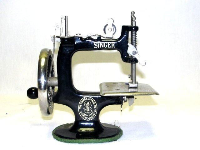 Singer Cast Child's Toy Sewing Machine: No. 20 Sew handy child toy sewing machine features the black painted 7-spoke hand wheel with a nickel plated rim, good gold decal work. Condition overall good. H. 6.5" W. 7'' D.3.75" " Very popular
