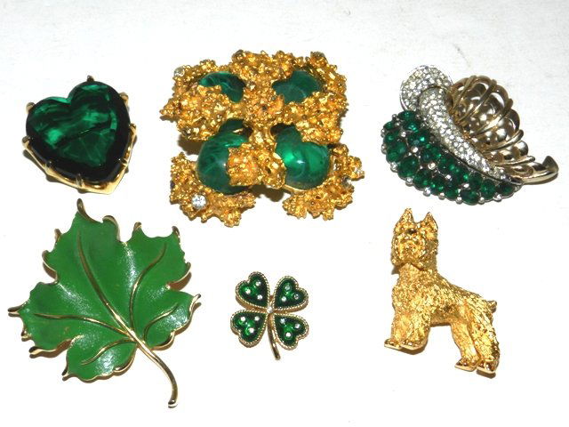 6pc Signed Costume Jewelry- Kenneth Lane: Including a large Kenneth Lane Gold Nugget brooch with rhinestones and faux glass emerald color stones, Heart shaped Bendikt pin, Trifari Scottie dog pin, Trifari 4 leaf clover pin, large Trifari leaf