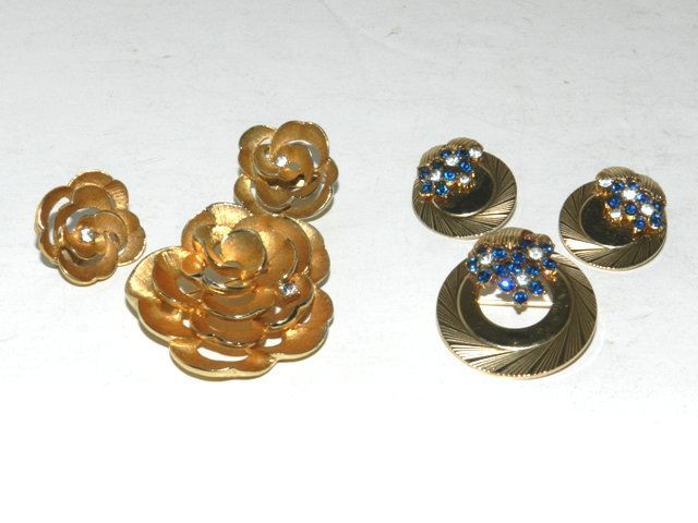 ESTATE BOUCHER Jewelry Sets: Including 3pc round gold colored set with clear and sapphire color rhinestones and a 3pc gold tone floral set with pin, earring s and rhinestone accents. Condition is good on both sets. All lots in th