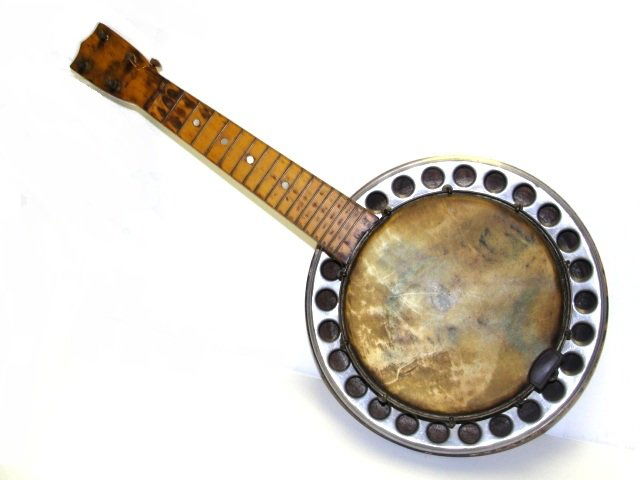Antique 4 String Banjo-Uke / Banjolele: Antique 4 string Banjo-Uke with resonator. Skin has painted face appearing to be a lady, painted worn. Measurements of the instrument are 22 1/4 inches long with the pot being approx 7 1/2 inches acro