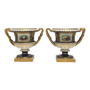 Pair of Artist Signed Royal Worcester Two Handled Urn Planters: Classical regency style Leadless Glaze porcelain urn planters by Royal Worcester of English. Fruit still life scenes, gold trim, cobalt blue main body and enamel work situated on square bases. Artist