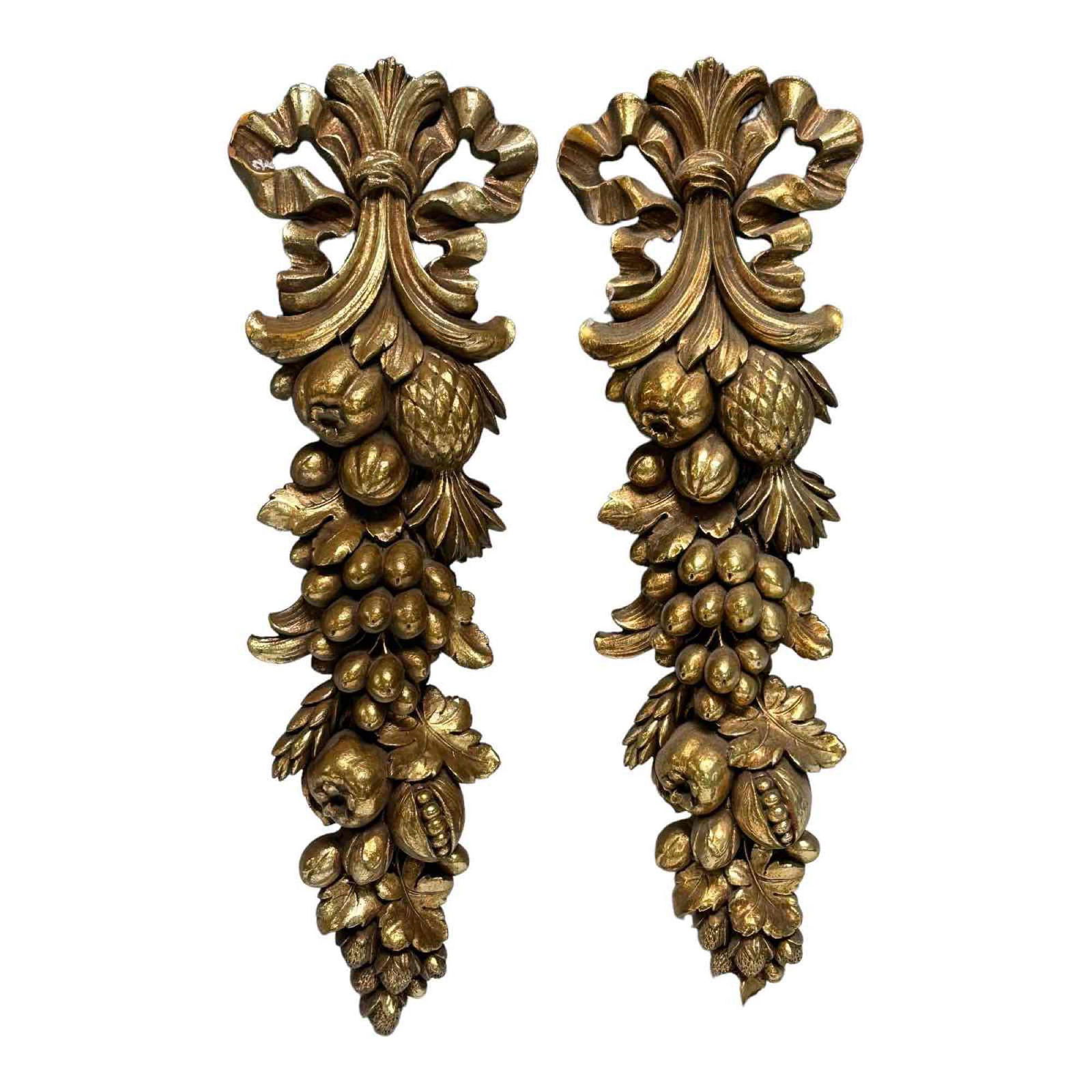 Pair of Gilt Wood Carved Fruit Wall Pediments: Pair of 20th century carved wooden wall pediments with gold leaf finish. Floral and fruit motif measuring approx 16" tall x 5" wide. Good condition and highly decorative, see photos.
