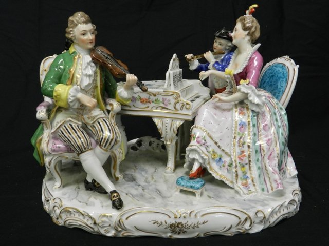 Dresden Musical Figurine: Large Dresden porcelian figurine of 3 musicans. 1 playing the violin, a woman pianist and young male playing flute. Gold trim with handpainted accents and transfer throughout. Approx 10 X 8 X 8", note