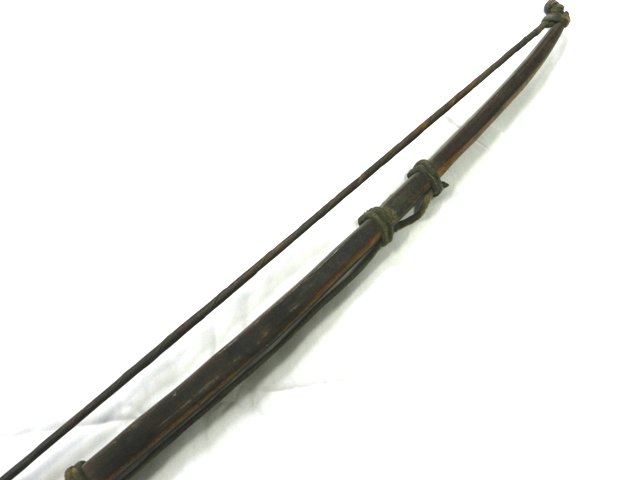 Primitive Whale Hunting Bow: 5.5' Primitive hunting bow with whale skin wrapped cord. Leather wrapped grip on a rosewood shaft. Overall condition good, late 19th C.