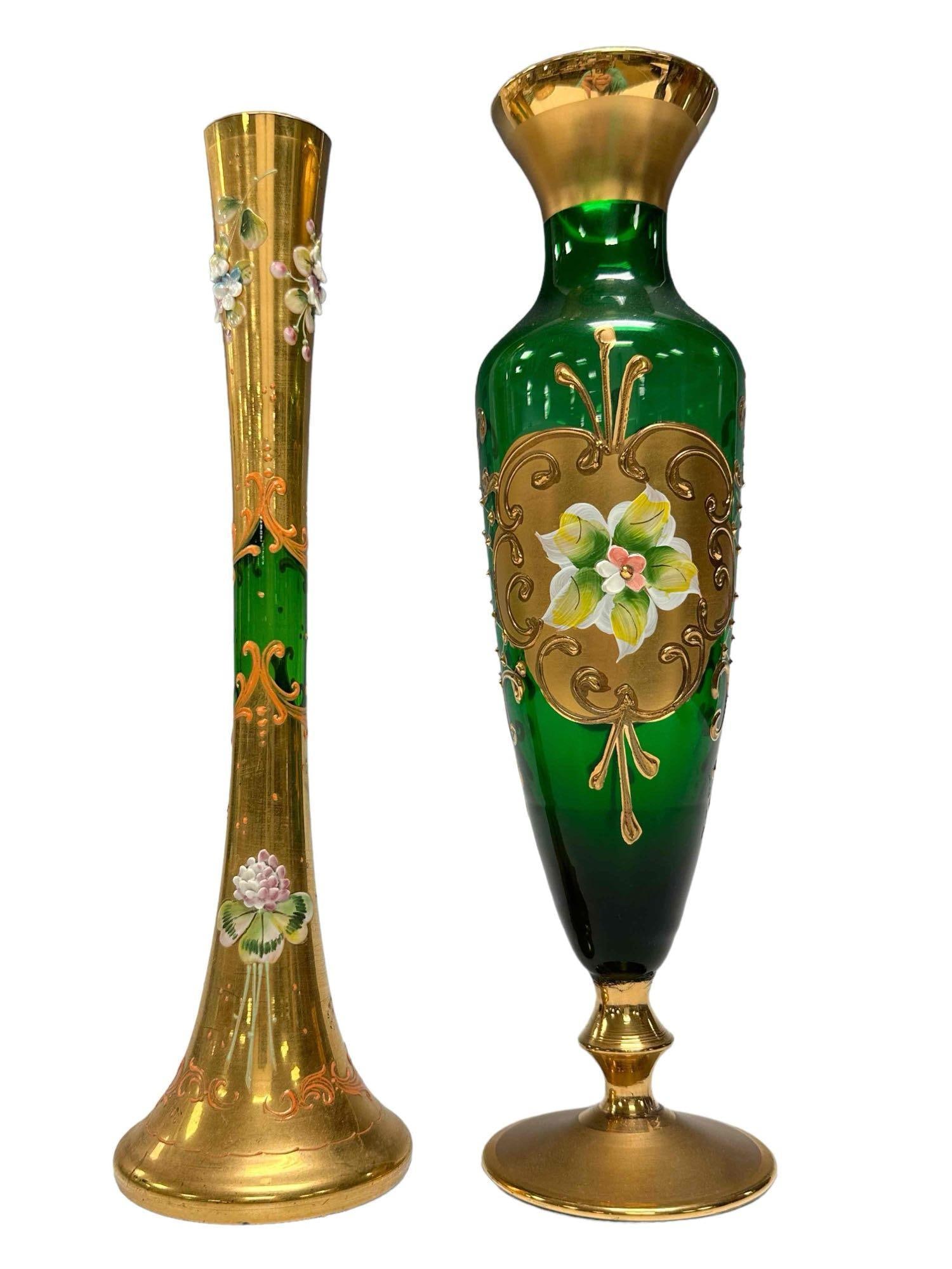Emerald Green Under Gold Moser Art Glass Vases (2): Raised relief pedestal and trumpet Moser vases. Both having raised relief flowers over enameled gold on emerald glass. Measuring approx. 10.25" to 10.75" tall. In good condition with no chips cracks o