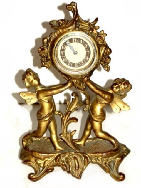 New Haven Figural Winged Cherub Clock: Gilted French ornate double figural dresser clock. Condition good working order, appropriate wear for age, some gilt loss on dia of face starting to show silver on rim of glass. 9 3/4'' Tall.