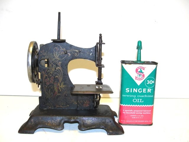 Little Beauty Childs Stenciled Sewing Machine: ca. 1900 cast metal with stenciling on both sides and base. Condition finish has allegation and missing crank for wheel. 7'' x 6'' x 3 1/2''.