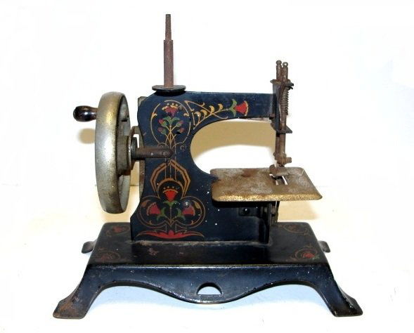 German Childs Stenciled Sewing Machine: Stenciled with floral designs old black toy sewing machine has a spread eagle with a key and made in Germany on the sewing platform. Condition overall good, minor scratches, surface rust on all old ch