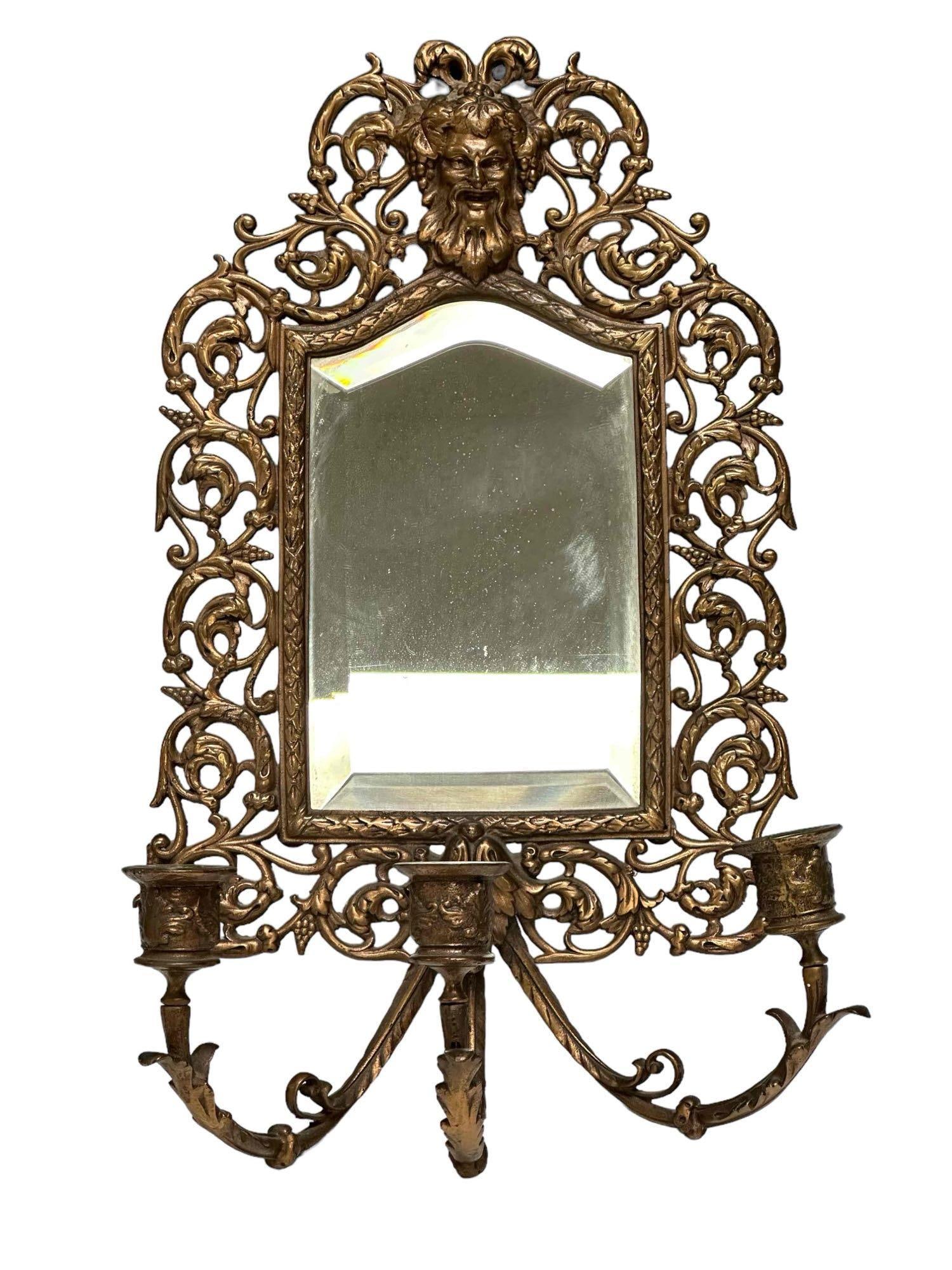 Bronze Three Light Mirrored Wall Sconce with BACCHUS: Baroque style three-light wall mirror sconce. Having bronze frame surmounted by mask of Bacchus the Wine god. Late 19th / 20th century. Measuring approx 17" tall x 10" wide. Light use and wear consist