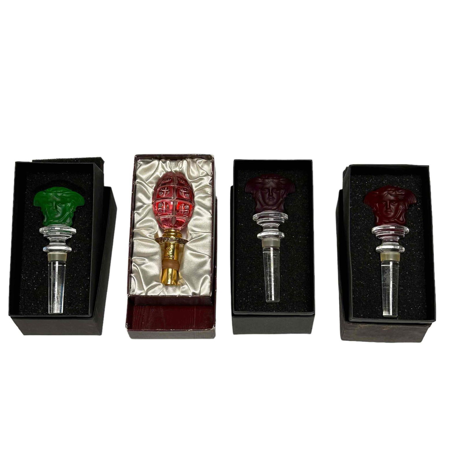 FABERGE and VERSACE Wine Bottle Stoppers: Including a Germany ruby to clear FABERGE stopper with box and three Rosenthal VERSACE Austrian crystal stoppers with colored tops as shown all in original boxes. All very good, light wear to the boxe