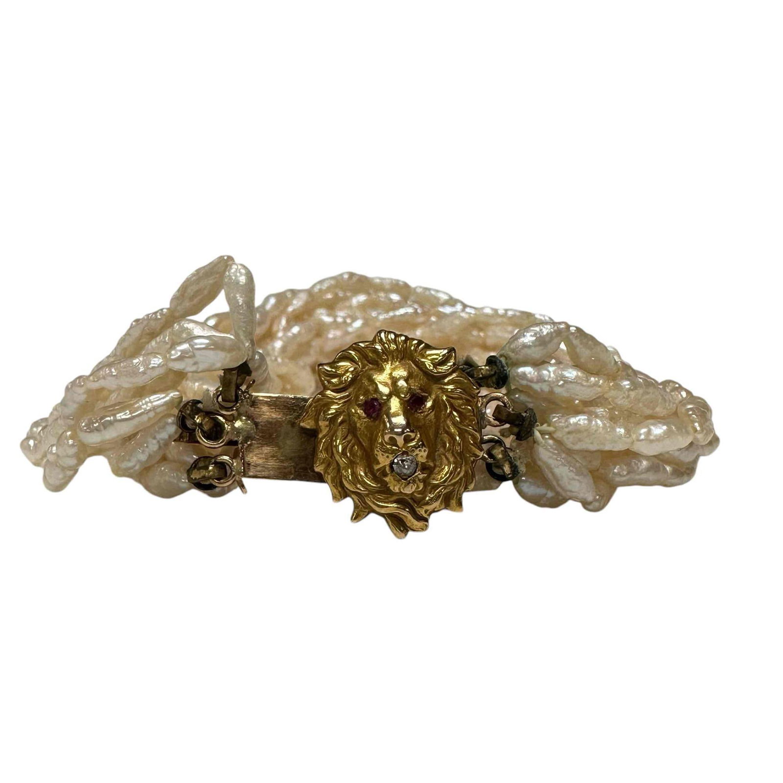 Freshwater Pearl Lion Bracelet: Freshwater pearl lion bracelet comprised with 14 strands of freshwater pearls, with a 14-karat yellow gold lion clasp, created with two rubies equaling approximately 0.04 carats, and one old mine-cut 